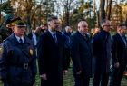 Uczestnicy wydarzenia stoją w parku.