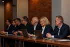 Uczestnicy posiedzenia siedzą przy stole.