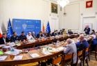 Sala plenarna, przy stole siedzą ludzie.