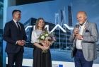 Marszałek Łukasz Smółka stoi na scenie. Obok stoi kobieta i Marek Maj.