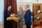 Uścisk dłoni towarzyszący przekazaniu sprzętu. Iwona Gibas z Zarządu Województwa Małopolskiego przekazuje strażacki uniform na ręce komendanta OSP Przeciszów oraz wójta gminy Przeciszów Tomasza Kosowskiego