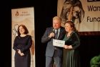 Burmistrz Chełmka Andrzej Saternus przekazuje przedstawicielkom WTZ symboliczny czek na 25 tysięcy złotych
