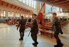 Poczet sztandarowy, młodzi ludzie w wojskowych mundurach, maszerujący przed ołtarz w kościele św. Józefa 