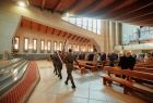 Poczet sztandarowy, młodzi ludzie w wojskowych mundurach, maszerujący przed ołtarz w kościele św. Józefa 