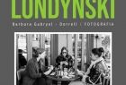 Grafika wystawy fotografii- na czarno-białym zdjęciu trzy kobiety siedzą przy stoliku przed kawiarnią i grają w karty