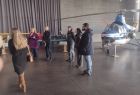 Goście z Mołdawii stoją w jednym z hangarów Muzeum Lotnictwa Polskiego w Krakowie. Na drugim planie stoi niebiesko-biały śmigłowiec z napisem Instytutu Lotnictwa.