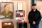 Praprawnuk gen. Stanisława Sosabowskiego przy gablotach muzealnych z portretem generała, jego sekretarzykiem i odznaczeniem od Królowej Holandii