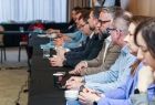 Grupa osób siedząca przy stole konferencyjnym.