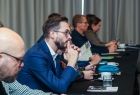Grupa osób siedząca przy stole konferencyjnym.
