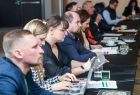 Grupa osób siedząca przy stole konferencyjnym.
