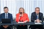 Grupa osób siedząca przy stole konferencyjnym.