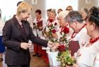 Iwona Gibas z zarządu województwa wręcza symboliczne upominki członkiniom zespołu śpiewaczego