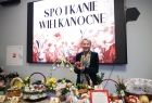 Iwona Gibas z Zarządu Województwa Małopolskiego stojąca przy pięknie udekorowanym i zastawionym potrawami świątecznym stole 