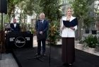 Kobieta w białej marynarce przy mikrofonie. 