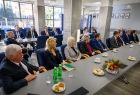 Grupa osób siedzących przy stołach.