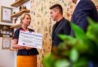 Iwona Gibas z zarządu województwa wręcza dwóm przedstawicielom miechowskiego samorządu symboliczny czek