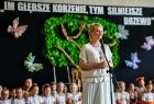 Iwona Gibas z zarządu województwa zwraca się do uczestników wydarzenia. Za panią marszałek siedzą dzieci, które przygotowały program artystyczny. W tle, na ścianie, znajduje się makieta drzewa, a nad nim napis: Im głębsze korzenie tym mocniejsze drzewo