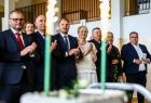 Iwona Gibas z zarządu województwa oraz samorządowcy oklaskujący występ dzieci