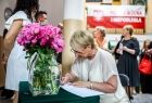 Iwona Gibas z Zarządu Województwa Małopolskiego wpisująca życzenia do księgi pamiątkowej