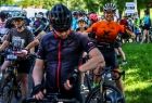 Rowerzyści w kasach i koszulkach sprawdzający przed startem ekwipunek