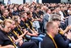 Pracownicy Stryker w firmowych koszulkach na widowni.