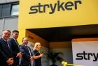 Marszałek Łukasz Smółka z dwoma mężczyznami i kobietą przed wejściem do firmy Stryker.