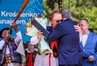 Wicemarszałek Witold Kozłowski w uścisku z kobietą w stroju regionalnym.