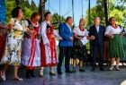 Grupa osób na scenie trzymająca się za dłonie.