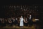 Iwona Gibas z Zarządu Województwa Małopolskiego zwracająca się do uczestników jubileuszowego koncertu. W tle orkiestra symfoniczna