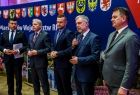 Marszałek Marek Woźniak przemawia do mikrofonu.