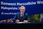Marek Woźniak Marszałek Województwa Wielkopolskiego podpisuje dokument.