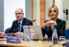 Dwie osoby siedzące przy stole konferencyjnym.