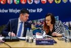Dwie osoby siedzące przy stole konferencyjnym.