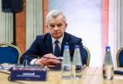 Osoba siedząca przy stole konferencyjnym.