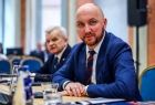 Dwie osoby siedzące przy stole konferencyjnym.