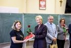 Iwona Gibas z zarządu województwa wręczająca uczestnikom spotkania tytułową książkę i różę