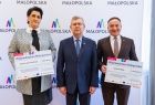 Kobieta i mężczyzna trzymający promesy, wśród nich wicemarszałek Witold Kozłowski.