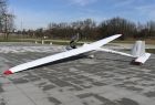 szybowiec PW-5 Smyk a otwartą kabiną stoi na płytach betonowych