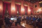 Zdjęcie przedstawia sytuację podczas koncertu w auli Collegium Novum UJ. Po lewej stronie zdjęcia siedzą muzycy instrumentaliści, po prawej - słuchacze koncertu.