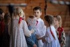 dzieci w strojach regionalnych bawiące się w ciuciubabkę na scenie 