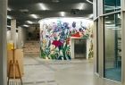 Korytarz w budynku, w tle widoczny kolorowy mural.