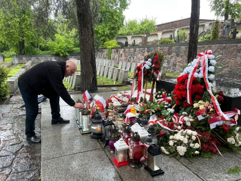 Wicemarszałek Ryszard Pagacz kładzie znicz na grobie.