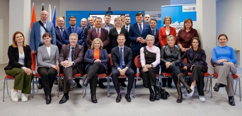 Ludzie siedzą i stoją na scenie.