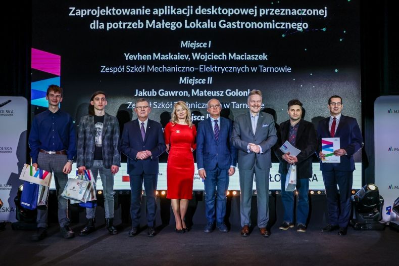 Wicemarszałek Witold Kozłowski z laureatami i nauczycielami na scenie.