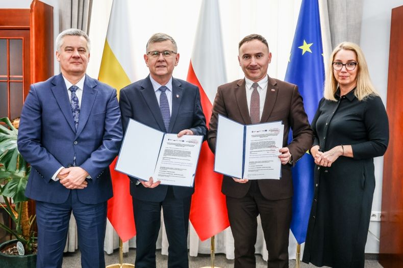 Wicemarszałek Witold Kozłowski i wójt Grybowa prezentujący umowy. Obok mężczyzna i kobieta.