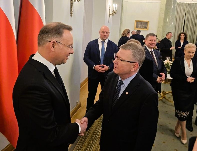 Prezydent Andrzej Duda i wicemarszałek Witold Kozłowski w geście uścisku dłoni.
