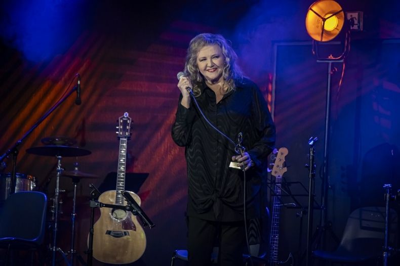 Anna Treter na scenie muzycznej z mikrofonem.