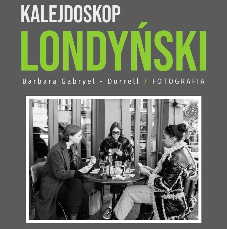 Grafika wystawy fotografii- na czarno-białym zdjęciu trzy kobiety siedzą przy stoliku przed kawiarnią i grają w karty