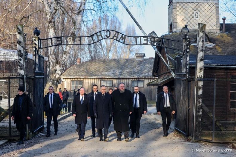 Prezydent RP Andrzej Duda przechodzi pod obozową bramą z napisem Arbeit macht frei w byłym niemieckim obozie koncentracyjnym i zagłady Auschwitz