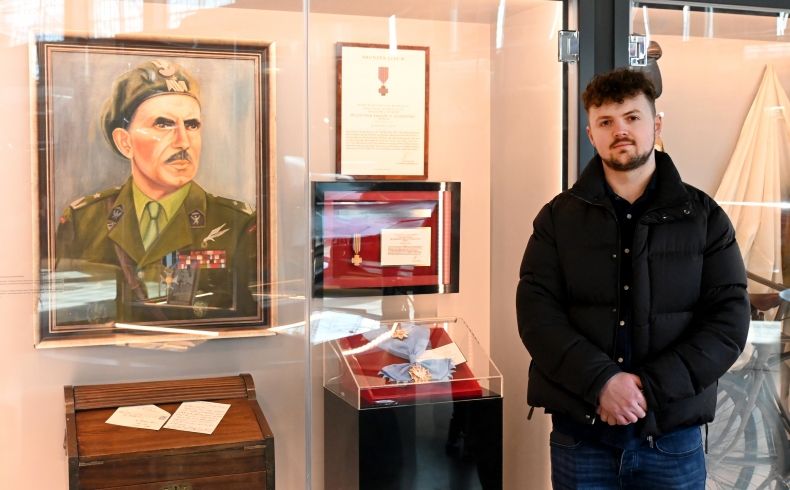 Praprawnuk gen. Stanisława Sosabowskiego przy gablotach muzealnych z portretem generała, jego sekretarzykiem i odznaczeniem od Królowej Holandii